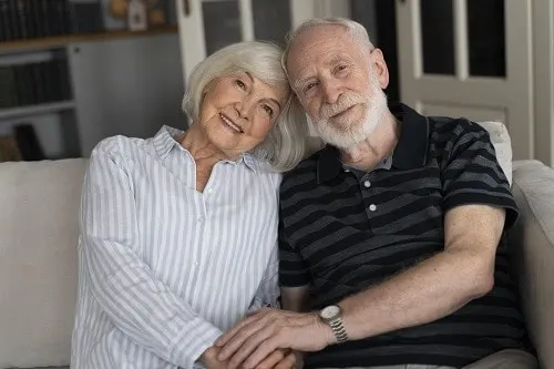 An older couple sitting together on a couch