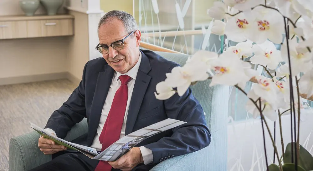 Lewis Chiat reading through a brochure in an armchair