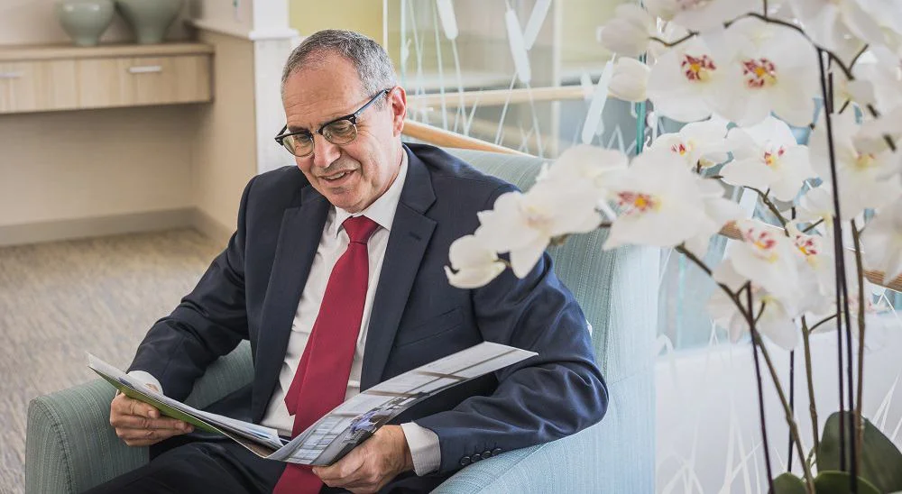 Lewis Chiat reading through a brochure in an armchair